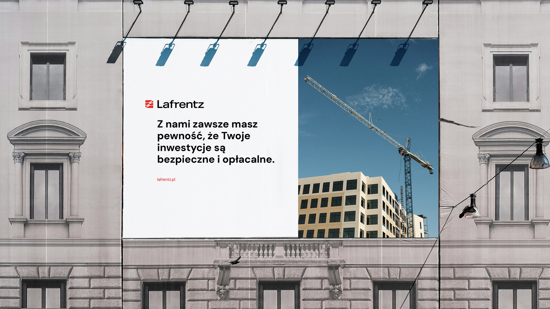 baner reklamowy firmy budowlanej na szarej, odnowionej kamienicy