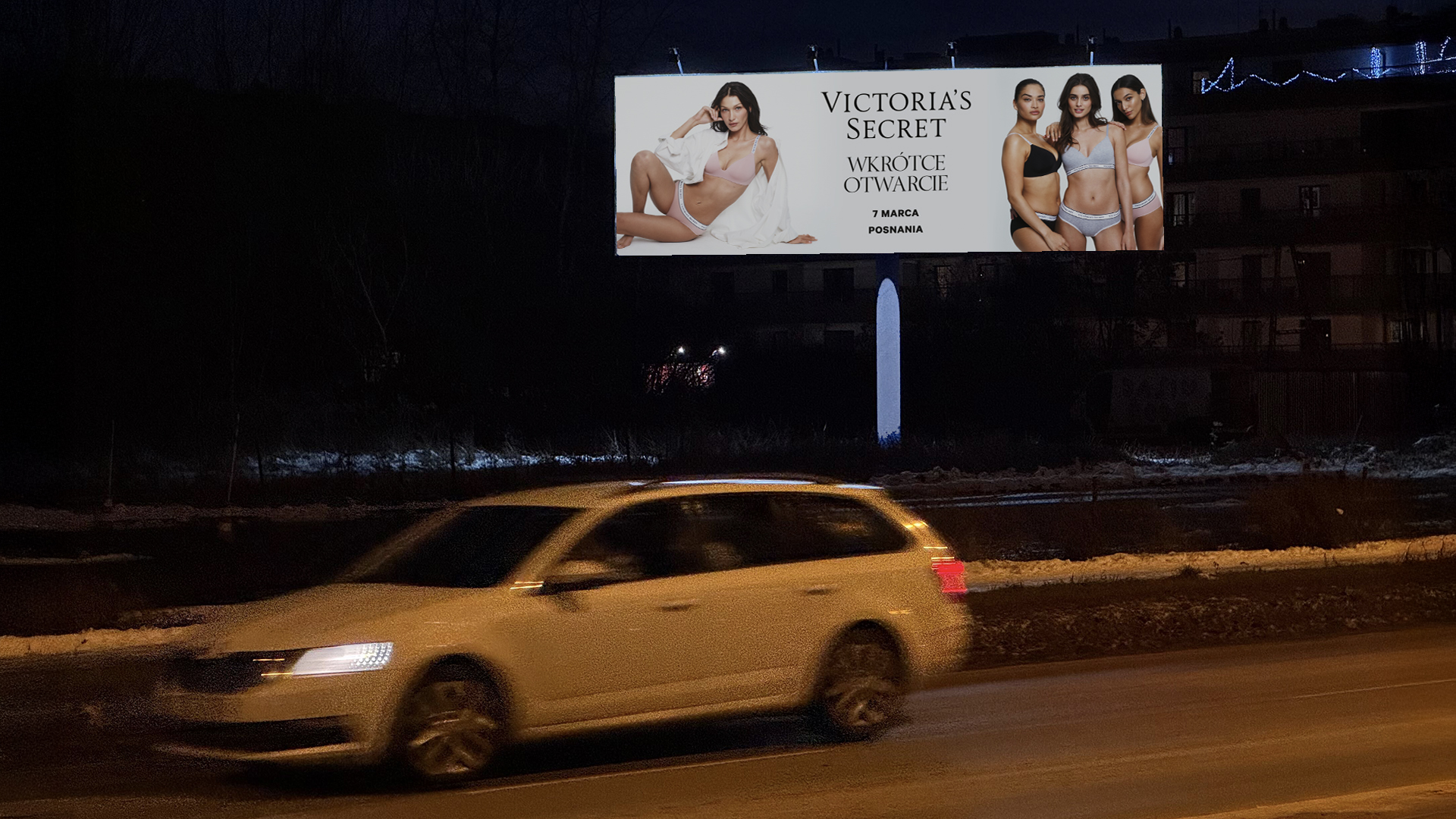 jasny bilboard z modelkami victoria's secret przy ruchliwej ulicy na tle wieczornego miasta